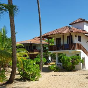 a house on the beach with palm trees at Tropical Garden in Tangalle