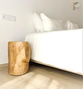 a bed with a wooden stump next to it at Pure Fonte Velha B&B in Vila do Bispo