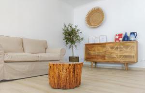 a living room with a couch and a tree stump coffee table at Pure Fonte Velha B&B in Vila do Bispo