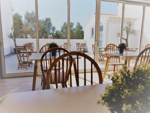 an empty patio with tables and chairs and windows at Pure Fonte Velha B&B in Vila do Bispo