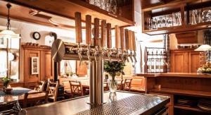 a kitchen with a bar with wooden cabinets and a table at Gasthof Adler in Ziemetshausen