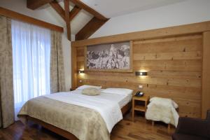 a bedroom with a large white bed and wooden walls at Hotel La Bussola in Andalo