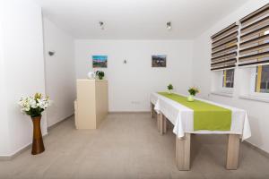 a dining room with a table and flowers on it at Green Villas Tjentiste in Tjentište