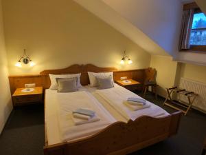 a bedroom with a large bed with two towels on it at Landhaus Sonnenbichl in Oy-Mittelberg