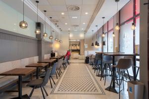 un restaurante con mesas y sillas de madera y gente sentada a su lado en Hotel & Spa Real Jaca, en Jaca