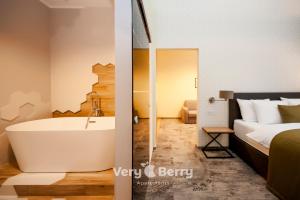 baño con cama y bañera junto a un dormitorio en Very Berry - Podgorna 1c - Old City Apartments, check in 24h, en Poznan