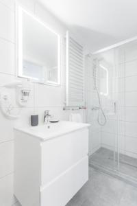 y baño blanco con lavabo y ducha. en WUCHTA WIARY Apartment, en Poznan