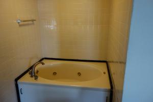 a bath tub in a tiled bathroom at VIP Inn and Suites in Huntsville