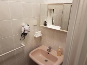 a small bathroom with a sink and a mirror at Apartments Zova in Medulin