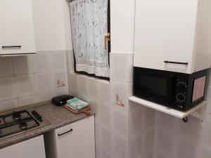 a small kitchen with a microwave and a stove at Apartments Zova in Medulin