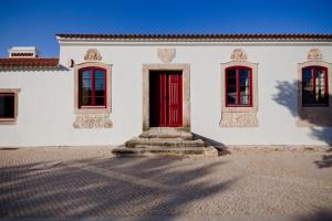 a white house with a red door and windows at Quinta da Lapa in Manique do Intendente