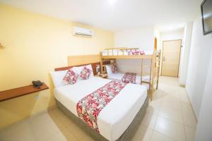 a bedroom with a bed and a bunk bed at Hotel Portobahia Santa Marta Rodadero in Santa Marta