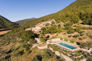 an aerial view of a house on a hill with a swimming pool at Borgo di Pianciano in Spoleto