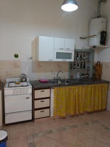 a kitchen with a white stove and a sink at Family Place II in Luján