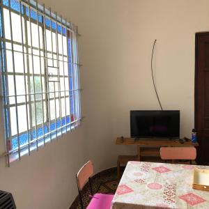 a dining room with a table and a television at Family Place II in Luján