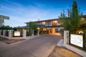 a house with a sign in front of a driveway at Garden City Motor Inn in Wagga Wagga