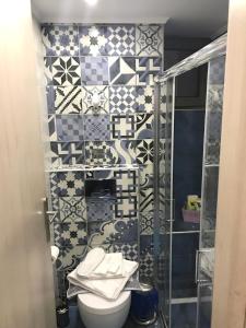 a bathroom with a toilet and a tiled wall at Odyssey Apartment in Palaiochora +13 photos