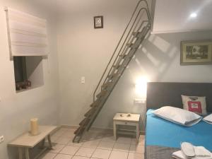a bedroom with a spiral staircase next to a bed at Odyssey Apartment in Palaiochora