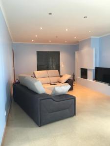 uma sala de estar com um sofá e uma televisão de ecrã plano em The Right Place to Relax em Santo António