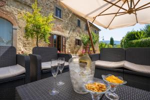 a table with wine glasses and snacks on a patio at Villa Borgo San Pietro in Cortona