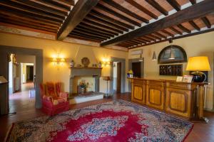 a living room with a red rug and a fireplace at Villa Borgo San Pietro in Cortona