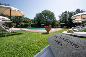 a stone bench with a sign that reads a hotel next to a pool at Villa Borgo San Pietro in Cortona