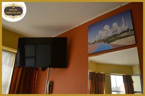 telewizor z płaskim ekranem na ścianie obok lustra w obiekcie Dubai Palace w mieście Lima