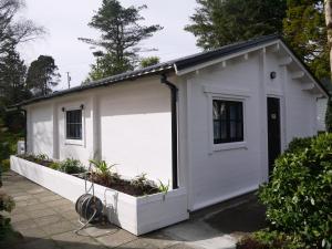 a white garage with a door and a window at Rodeen in Castletownbere