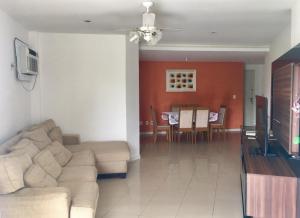 ein Wohnzimmer mit einem Sofa und einem Esszimmer in der Unterkunft Recreio dos bandeirantes in Rio de Janeiro
