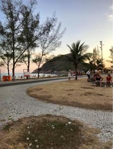 un grupo de personas sentadas en un parque cerca de la playa en Recreio dos bandeirantes, en Río de Janeiro