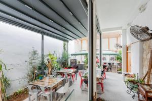 un patio con mesas, sillas y ventanas en TasEV Guesthouse en Lefkosa Turk