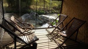three rocking chairs sitting on a porch with a window at Repousada Sana in Sana