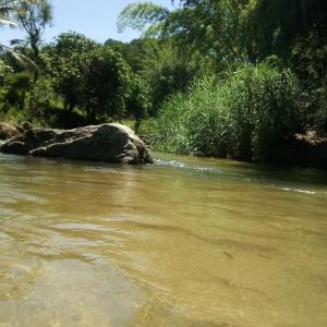 a river with a large rock in the water at Repousada Sana in Sana