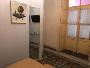 Habitación con puerta, mesa y espejo en Hotel Elena en Puebla