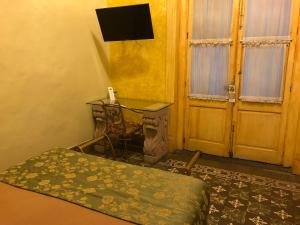 a room with a bed and a table and a door at Hotel Elena in Puebla +43 photos