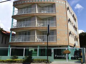 a tall building with two dogs sitting on the balconies at Praia Pousada Tatuíra in Florianópolis