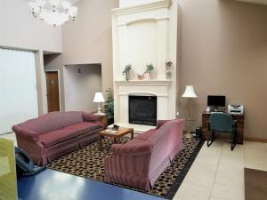 a living room with two couches and a fireplace at Abby Inn in Abbotsford