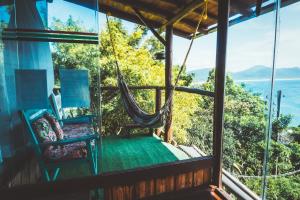 a room with a hammock and a view of the ocean at Hostel do Morro in Florianópolis