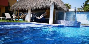 a swimming pool with two hammocks and a resort at Chalet en Puerto San Jose in San José de Guatemala