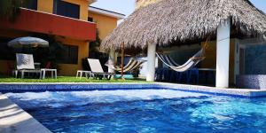 a resort with a swimming pool with hammocks and a building at Chalet en Puerto San Jose in Puerto San José