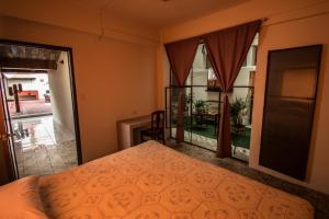 a bedroom with a bed and a view of a patio at Casa de Juan Hostal in Xalapa
