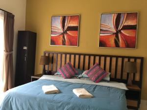 um quarto com uma cama azul com duas toalhas em Happy Stay @ Morib Gold Coast em Banting