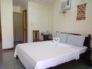 a bedroom with a white bed with a swan on it at SUNSHINE PARADISE Inn in Bantayan Island