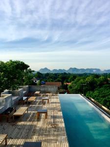 a swimming pool with benches on the roof of a house at Inchantreedoopool in Kanchanaburi City
