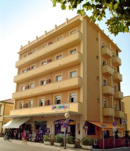 a large yellow building on the side of a street at Residence Carioca in Rimini