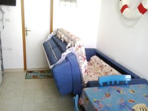 um sofá azul num quarto com uma cama em Grottammare mon amour Marina Piccola em Grottammare