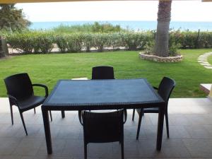 un tavolo e sedie con l'oceano sullo sfondo di Holiday home in Costa Rei 22891 a Costa Rei