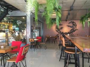 un restaurante con mesas de madera y sillas rojas en Maneetel Krabi Beachfront-SHA Plus, en Ao Nang Beach