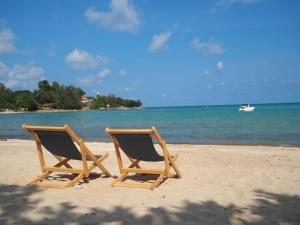 two beach chairs sitting on top of a sandy beach at Samui Garden Home - SHA Extra Plus in Lamai