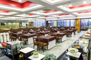 塞恩Hotel Tip Top Plaza的一间有桌椅的大餐厅